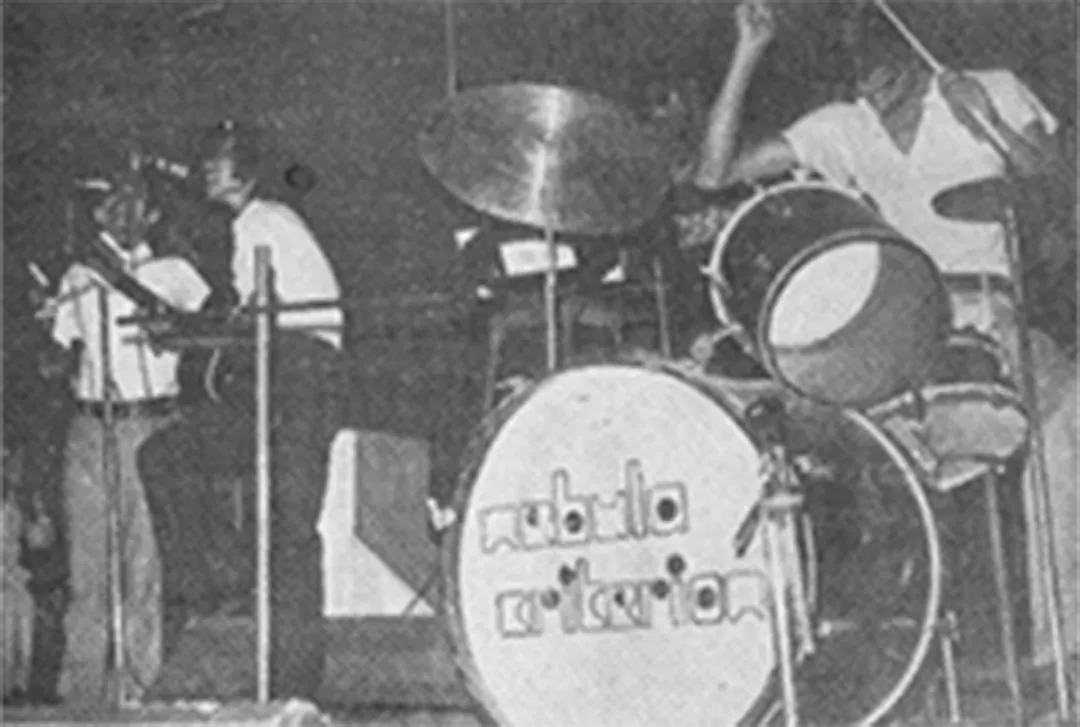 A band plays, the drummer behind a bass drum painted with the band’s name