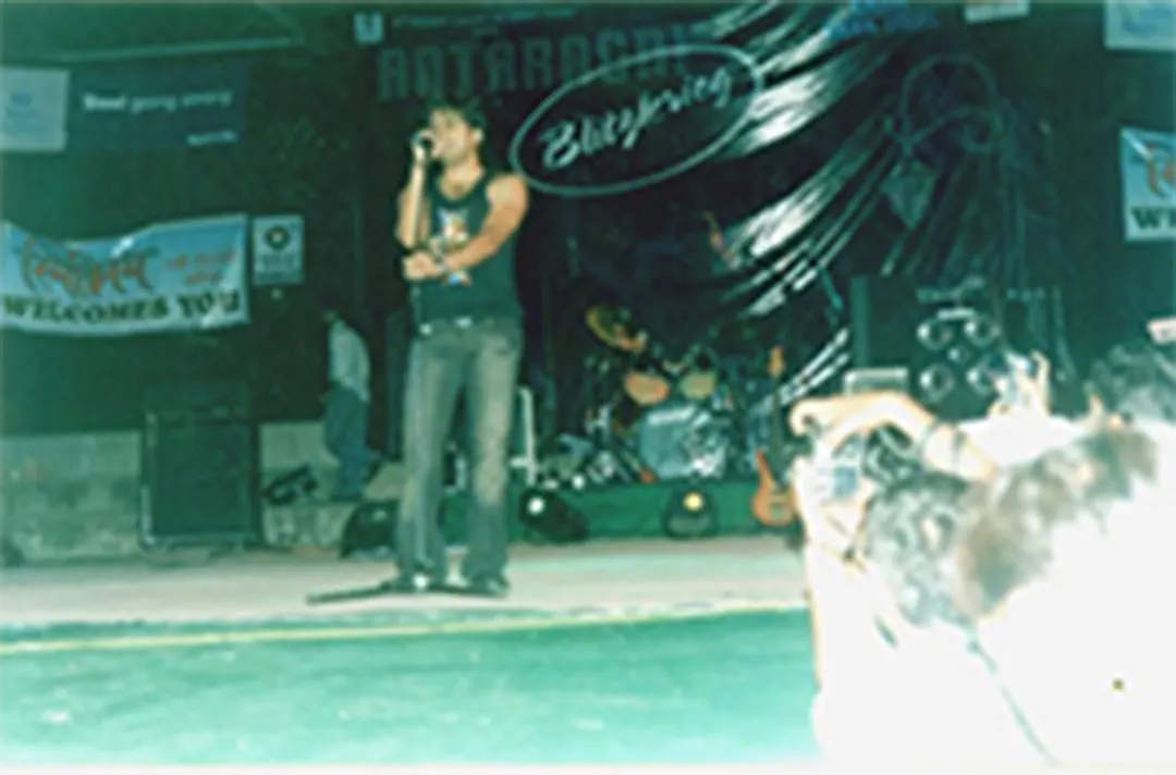 A singer at the microphone, the stage lit green
