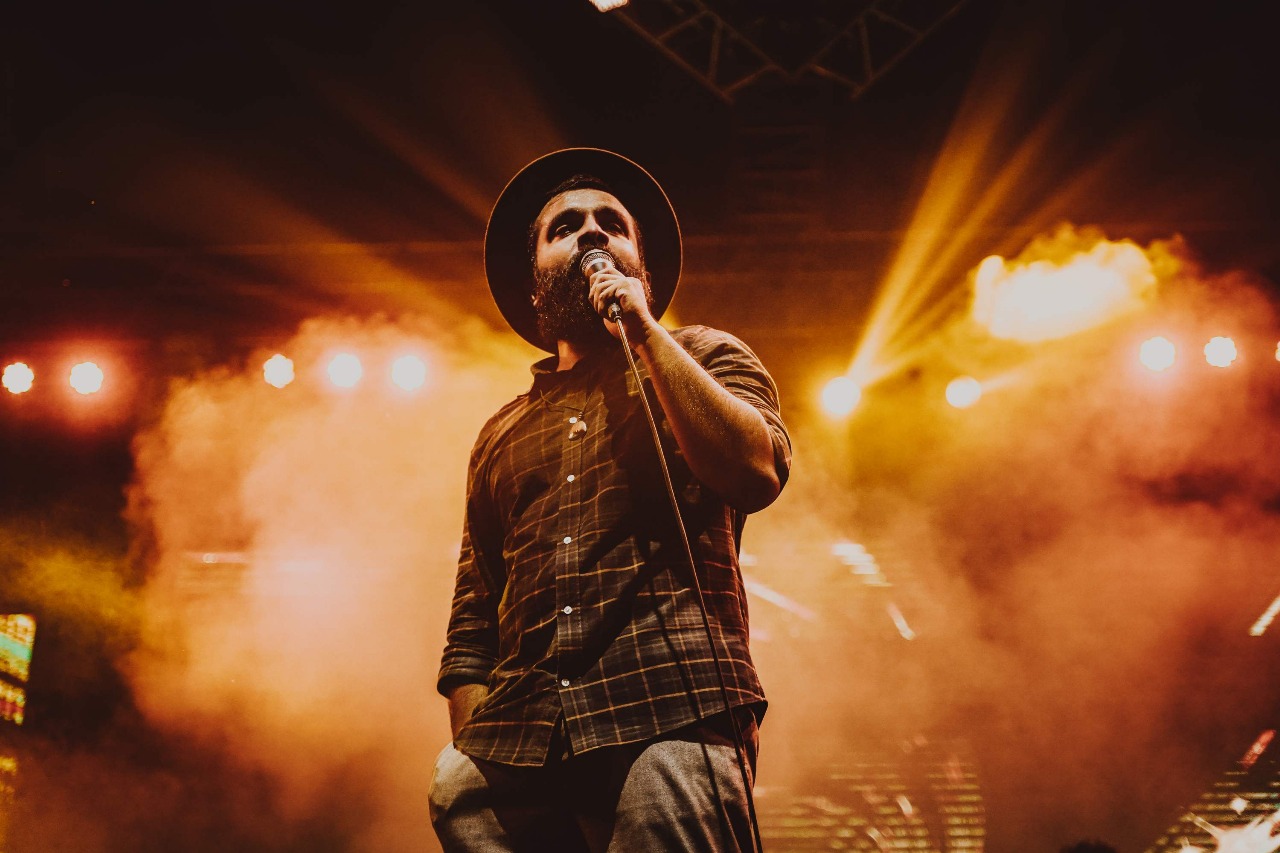 A singer performing live on stage with dramatic lighting